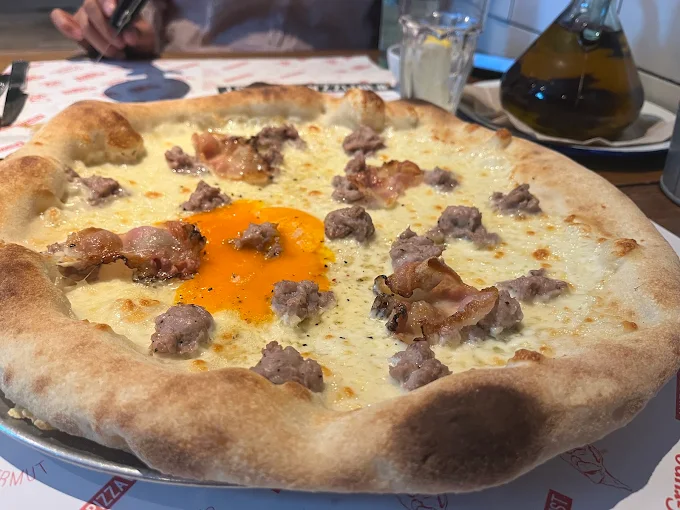 Pizza napolitana de Porco Dio con yema de huevo, longaniza y borde alto tostado