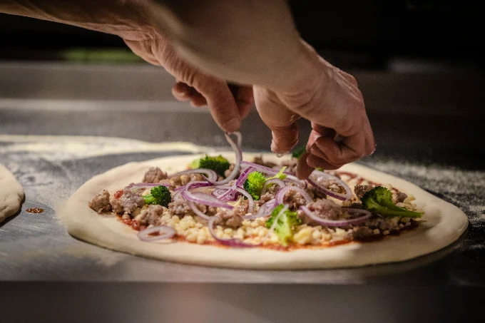 Pizzero de Porco Dio montando una pizza napolitana a mano